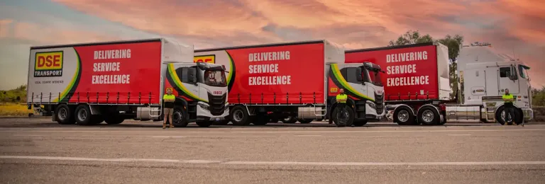 A convoy of white trucks with yellow and red DSE logos. The image represents DSE's improvements to worker induction and onboarding.