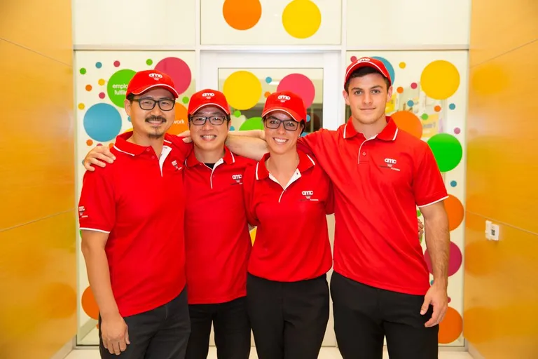 a group of a happy workers in red AMC cleaning uniforms