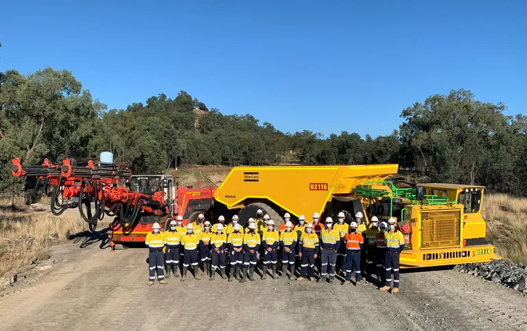 a group of workers in high vis and hard hats on a mining site