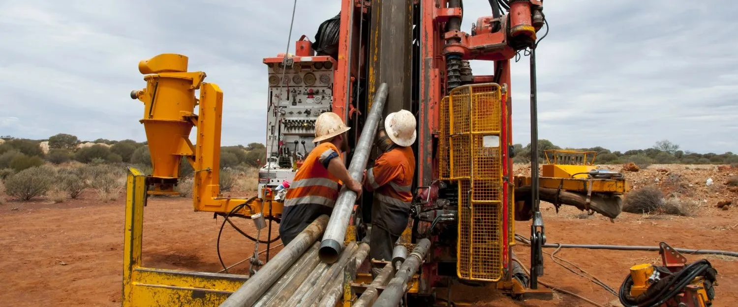 Two mining workers operating heavy drilling equiptment