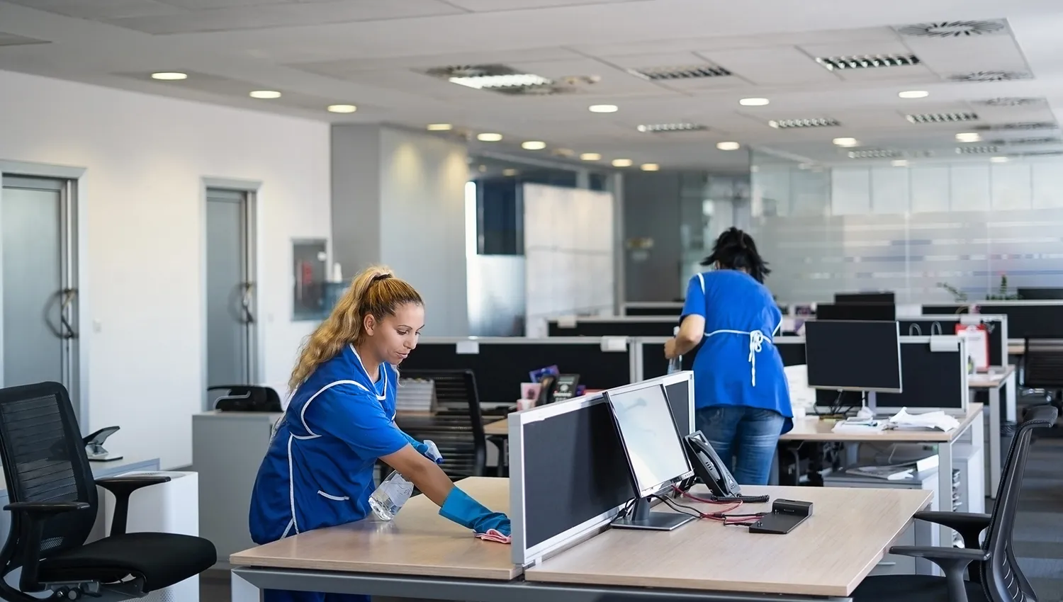 two cleaning workers cleaning an office building