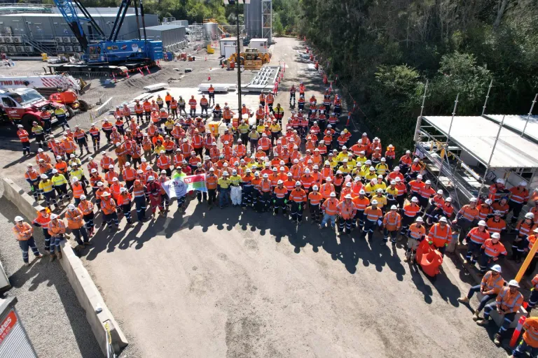 Overhead view of workers on a construction site in hard hats and high-visibility clothing. Image represents how Clough managed complex inductions.