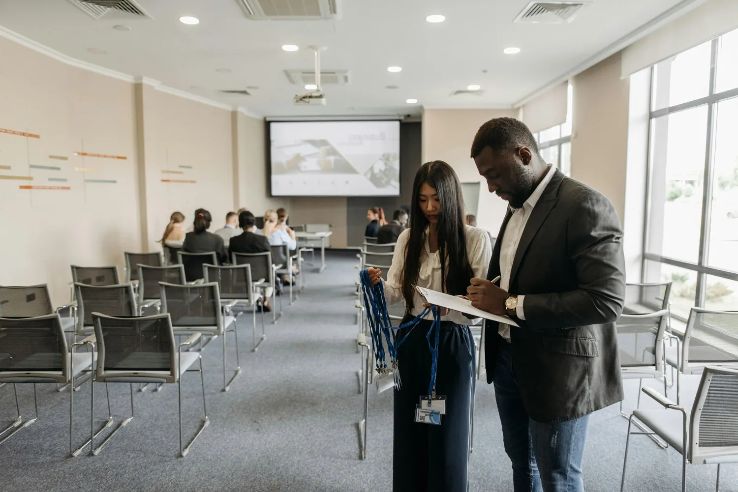 2 HR staff sorting out lanyards in a conference room during a new employee induction session