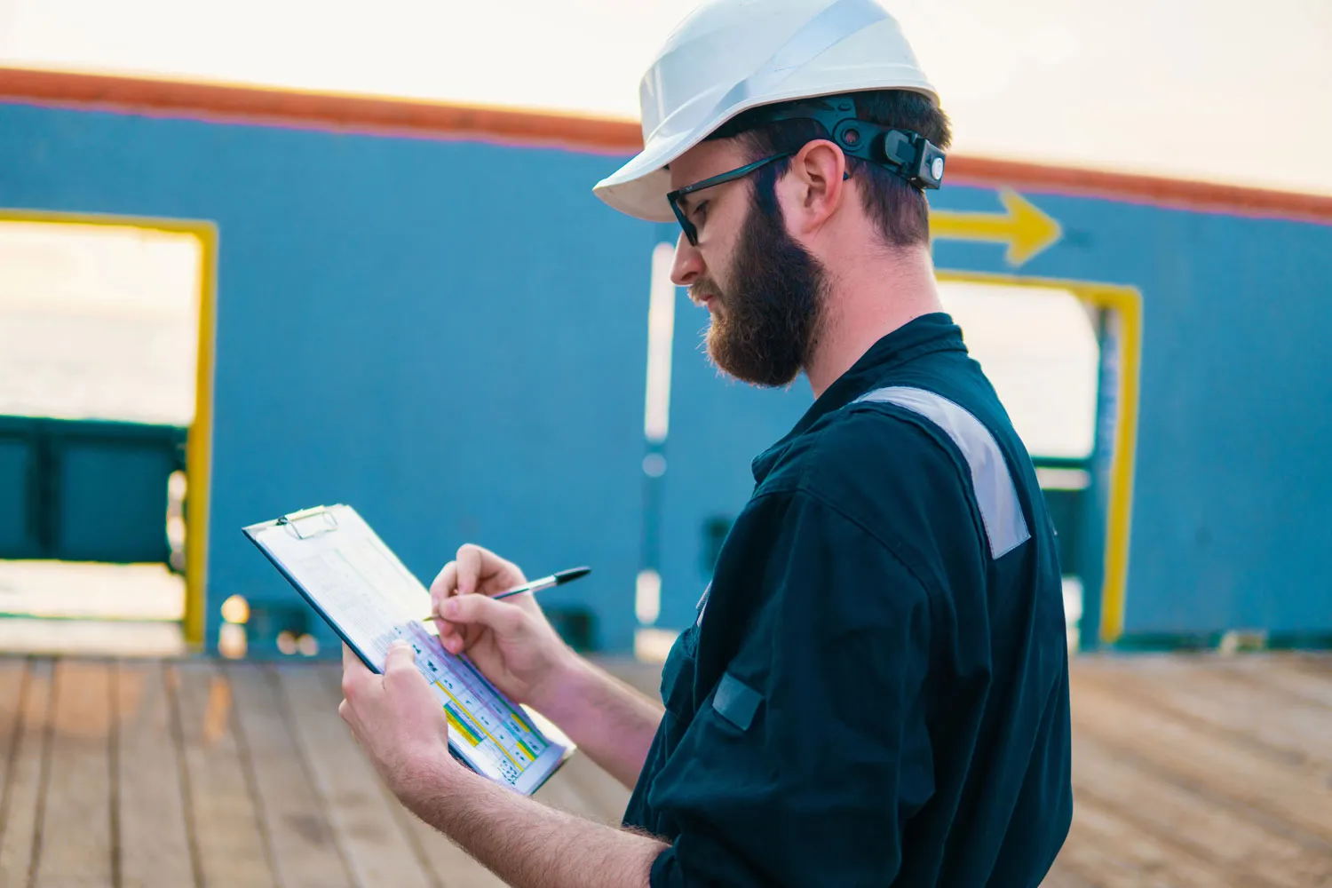 Worker in PPE completing a pre-start safety checklist