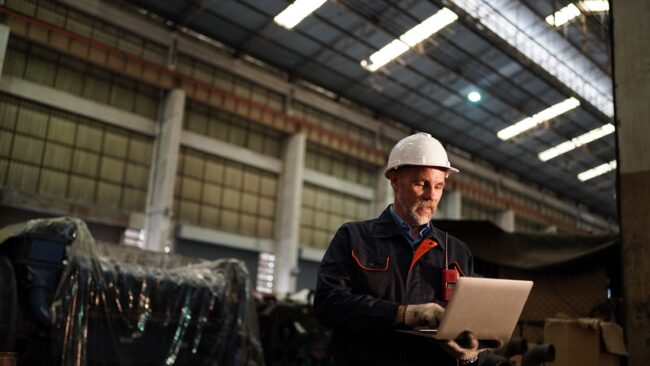 a man with a white hard hat on in a warehouse